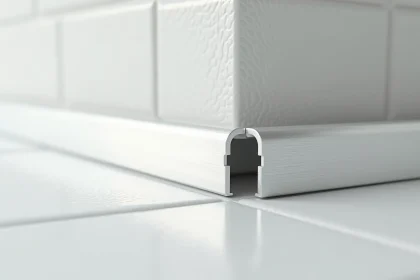 Cornière en aluminium anodisé installée à l'angle d'un carrelage blanc en salle de bain, finition soignée et joint précis