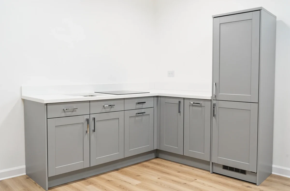 Cuisine Hygena avec façades grises style shaker et plan de travail blanc dans un showroom accessible
