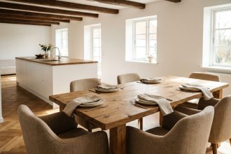Grande table à manger familiale en chêne massif avec six chaises rembourrées dans une salle à manger ouverte aux tons chaleureux
